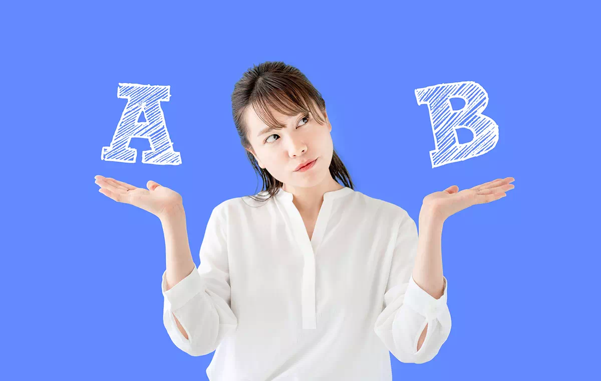 AとBを天秤に掛け悩んでいる女性の画像