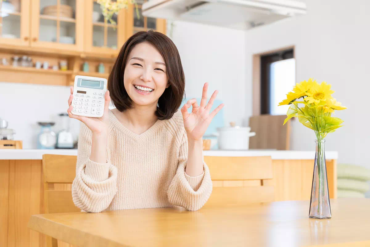 笑顔で電卓を持つ女性の画像